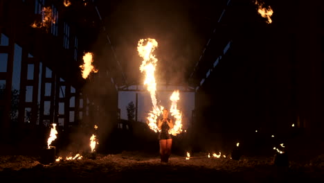 Professional-fire-show-in-the-old-hangar-of-the-aircraft-show-professional-circus-artists-three-women-in-leather-suits-and-a-man-with-two-flamethrowers..